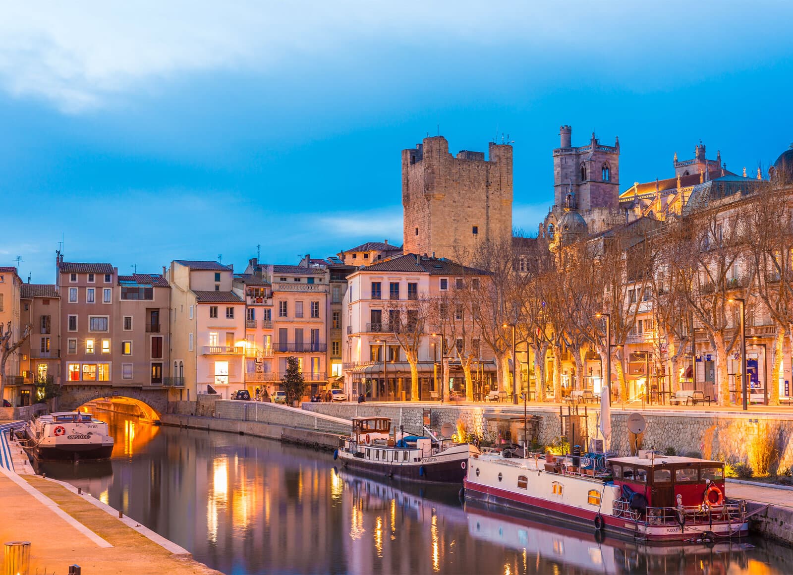 Le canal de la Robine à Narbonne au crépuscule, péniches et centre historique
