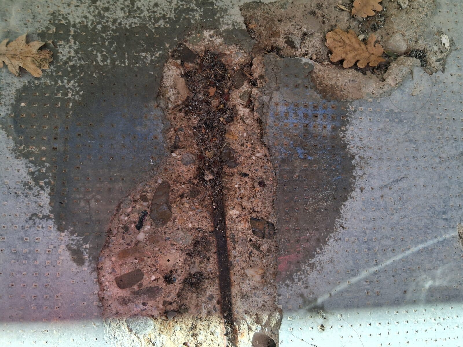 Sous-face en béton avec enrobage éclaté et armature apparente corrodée