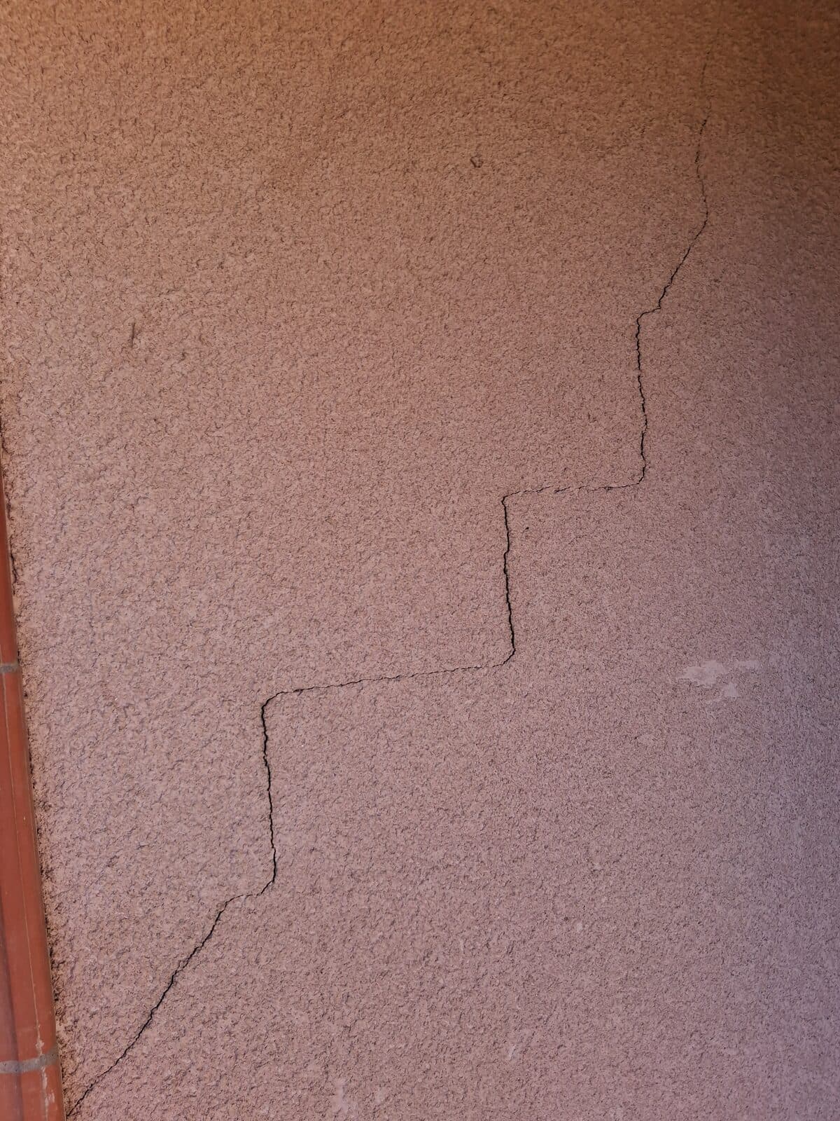 Fissure en escalier sur un enduit de façade, désordre typique du retrait-gonflement des argiles